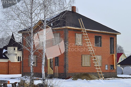 Image of Crack on a brick wall of a two-storeyed unfinished cottage.