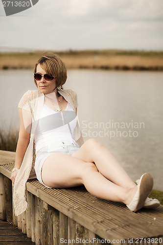 Image of woman in shorts next to lake