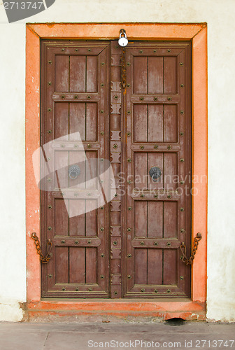 Image of Old wooden door on a building facade. India, Agra