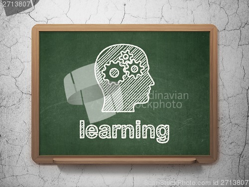 Image of Education concept: Head With Gears and Learning on chalkboard background