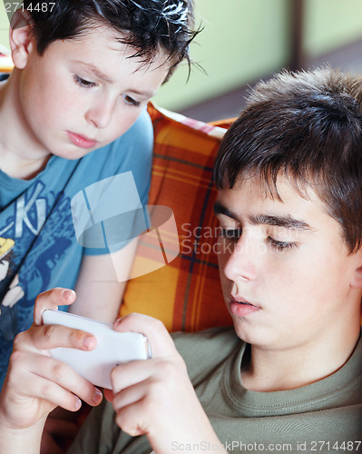 Image of Teenager boys playing on smartphone, outdoor