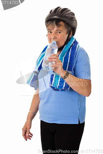 Image of Senior woman with helmet drinking
