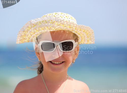 Image of happy little girl in sunglasses on beach