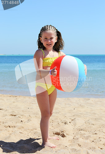 Image of happy little girl with ball on beach