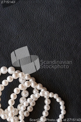Image of White pearls on the black silk as background