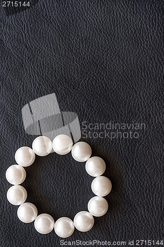 Image of White pearls on the black silk as background