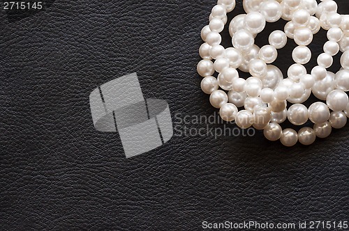 Image of White pearls on the black silk as background