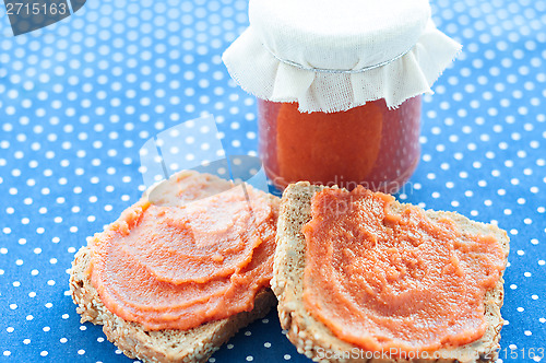 Image of Slice of bread with quince jam and a jar of homemade jam from a quince