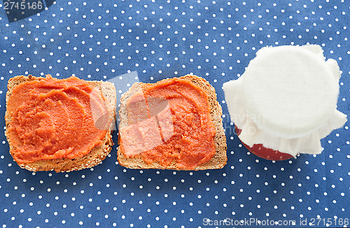 Image of Slice of bread with quince jam and a jar of homemade jam from a quince