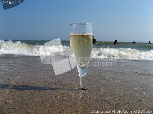 Image of Glass of a cold champagne in warm sea waves on a beach 2