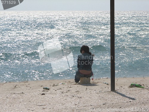 Image of The girl in loneliness sits in the afternoon at sea coast