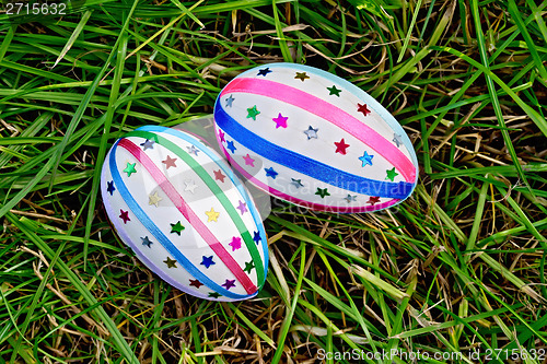 Image of Easter eggs with ribbons and sequins on grass