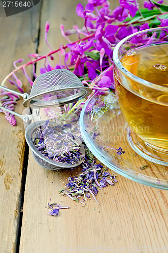 Image of Herbal tea in cup of fireweed with a strainer on board