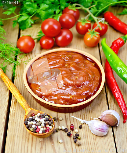 Image of Ketchup in pottery with spices on board