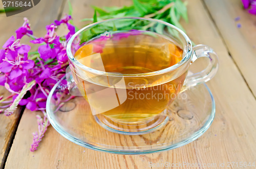 Image of Herbal tea in glass cup of fireweed on board