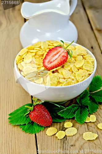 Image of Cornflakes with strawberries and milk on board