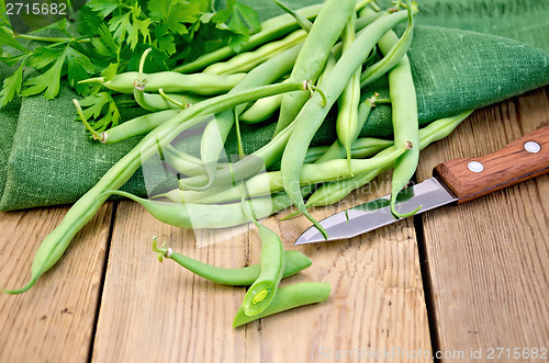 Image of Beans green on the board with a knife