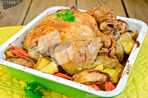 Image of Chicken baked with vegetables in tray on board