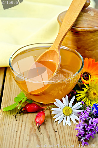 Image of Honey with flowers and spoon on board