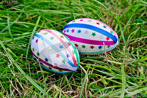 Image of Easter eggs with ribbons and stars on grass