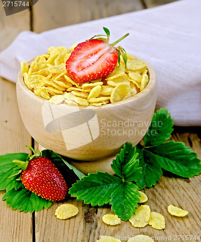 Image of Cornflakes in wooden bowl with strawberries on board