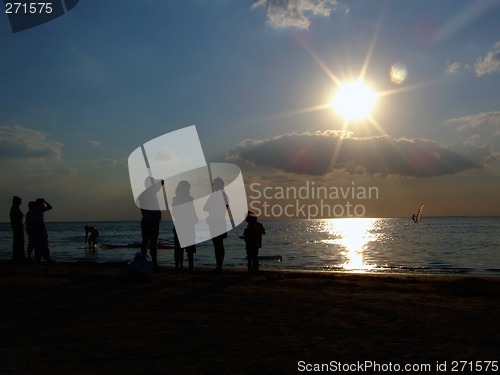 Image of Silhouette of people looking at windsurf at sunset 2