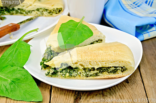 Image of Pie spinach and cheese with leaves and knife