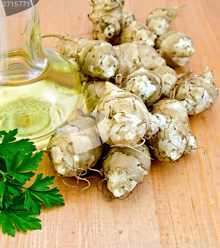 Image of Jerusalem artichokes with oil and parsley on board