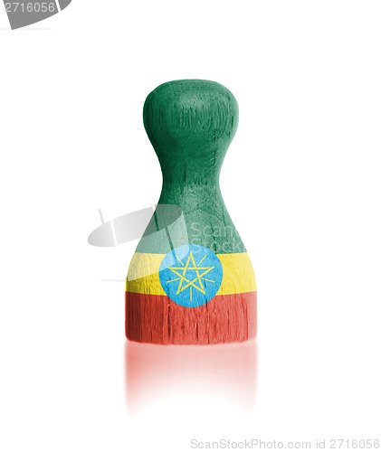 Image of Wooden pawn with a painting of a flag