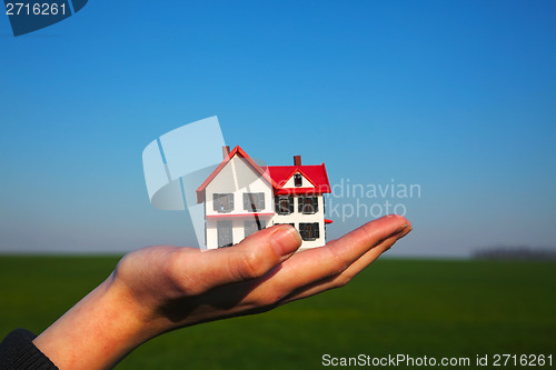 Image of Female hand holding model of residential building