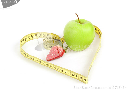 Image of green apple with a measuring tape and heart symbol isolated