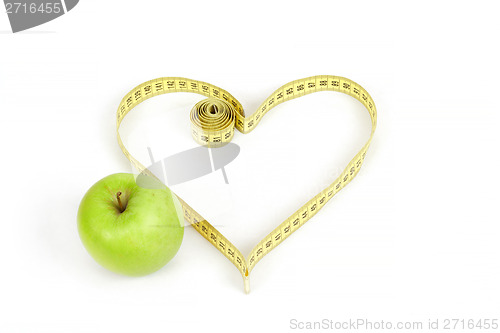 Image of green apple with a measuring tape and heart symbol isolated