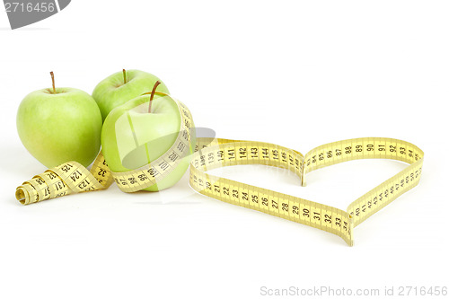 Image of green apple with a measuring tape and heart symbol isolated