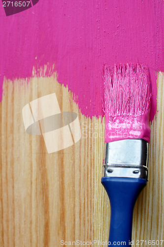 Image of Closeup of pine plank being painted