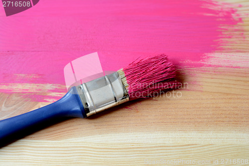 Image of Half-painted wood with paintbrush