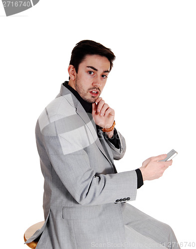 Image of Young man holding cell phone.