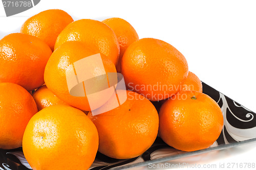 Image of Large ripe tangerines in a glass dish on a white background.