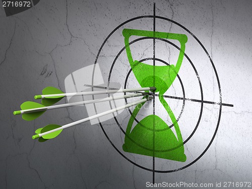 Image of Time concept: arrows in Hourglass target on wall background