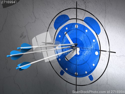 Image of Time concept: arrows in Alarm Clock target on wall background