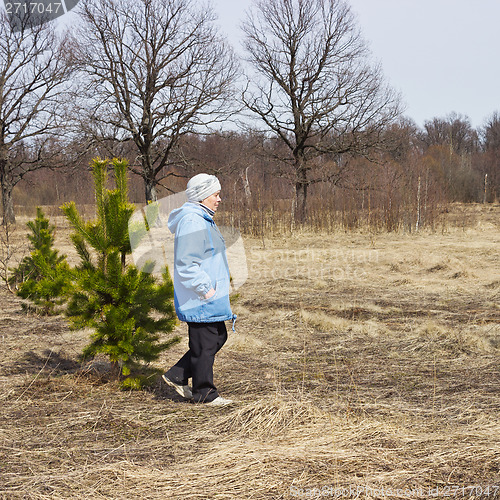 Image of Mature woman walking in woods in spring