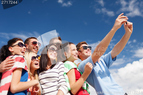 Image of group of friends taking picture with smartphone