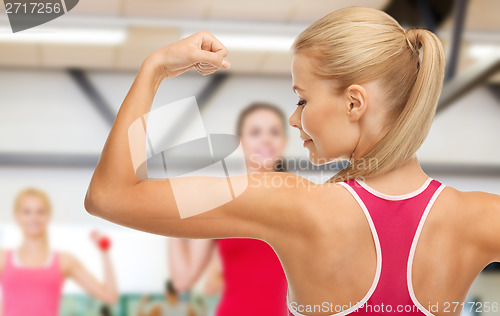 Image of sporty woman showing her biceps