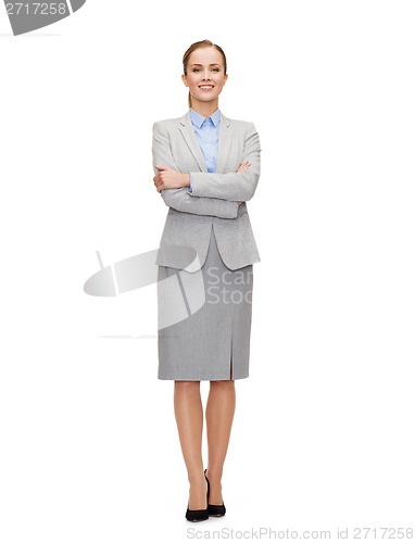 Image of young smiling businesswoman with crossed arms
