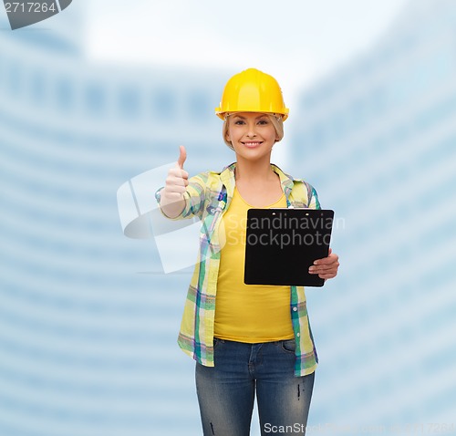 Image of smiling woman in helmet with clipboard