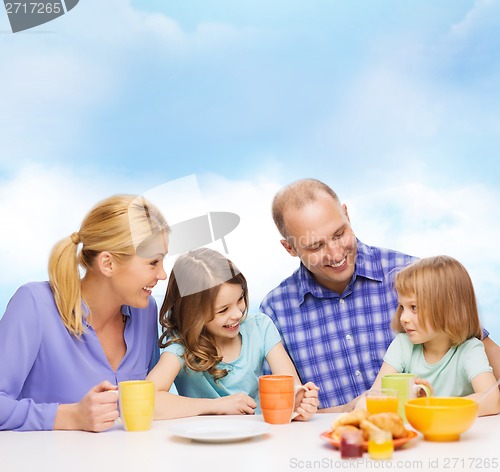 Image of happy family with two kids with having breakfast