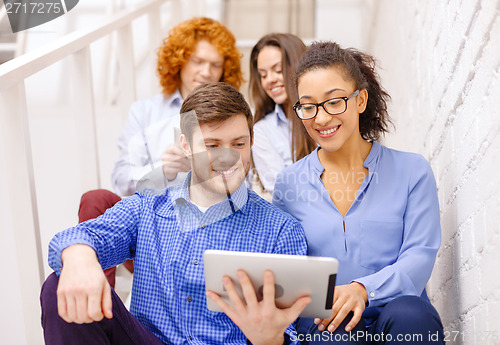 Image of team with tablet pc computer sitting on staircase