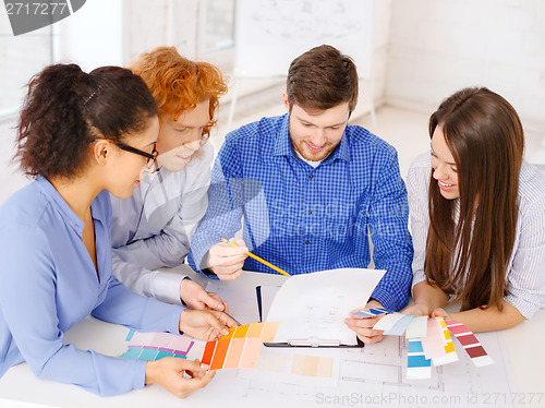 Image of team with color samples and blueprint at office