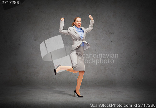 Image of happy woman jumping with hands up