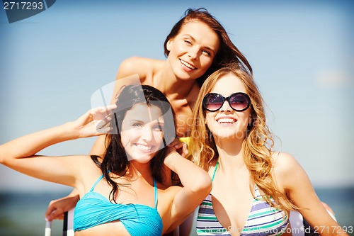 Image of girls sunbathing on the beach chairs