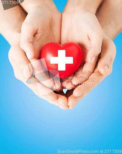 Image of male and female hands with red heart